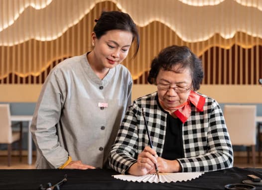 Recreation therapist helping with calligraphy